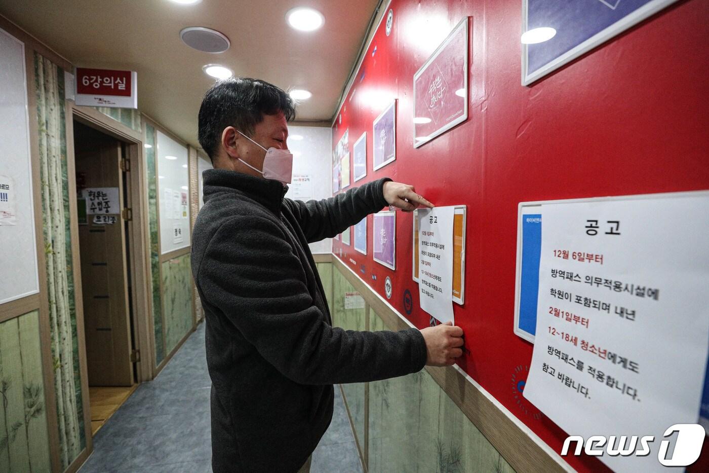 6일 오후 서울 시내의 한 학원에서 관계자가 방역패스 관련 안내문을 교실 등에 붙이고 있다. 2021.12.6/뉴스1 ⓒ News1 성동훈 기자