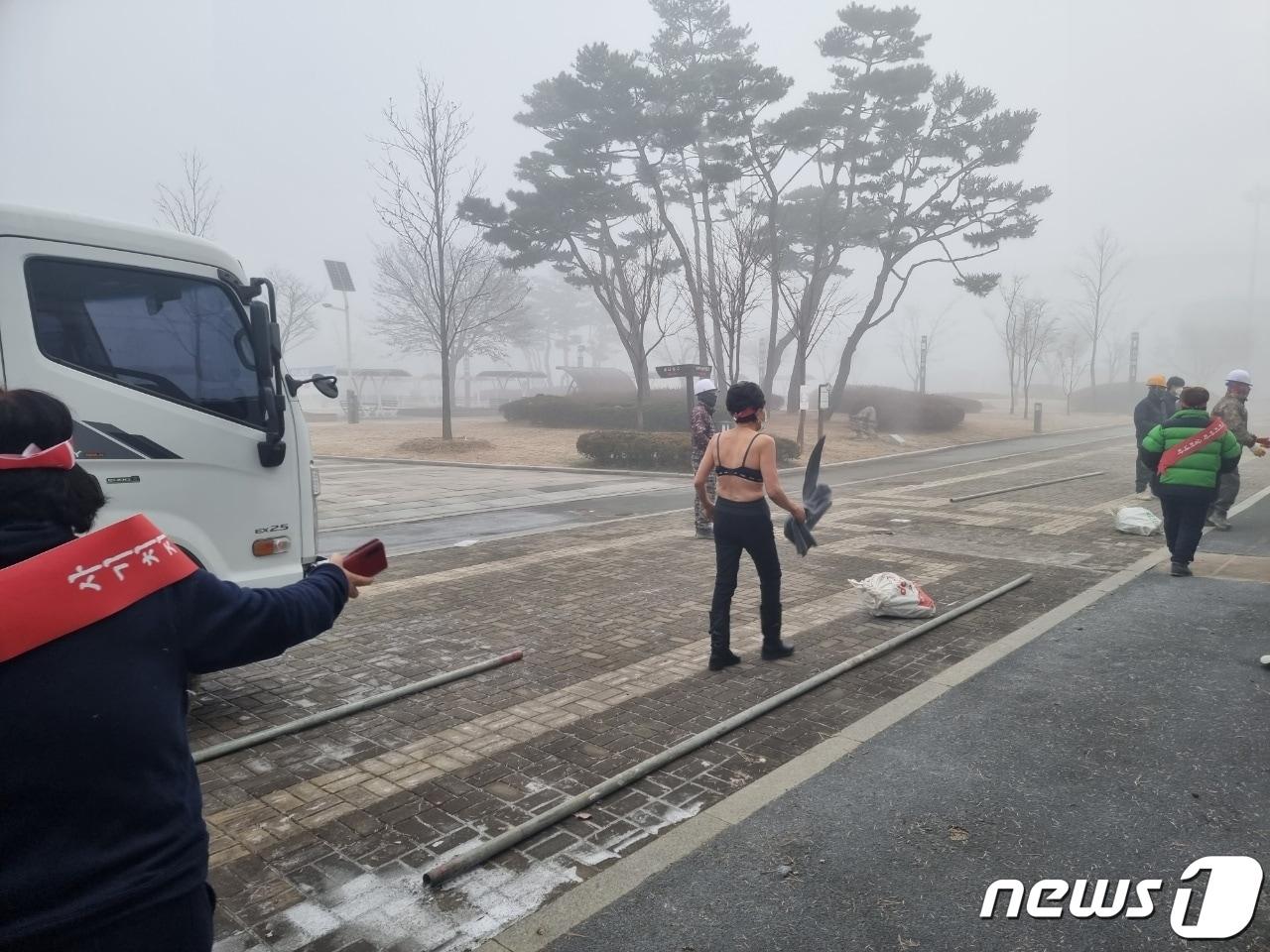 본문 이미지 - 6일 오전 충북 충주시가 라이트월드 상가 철거를 시도하자 상인회 관계자가 옷을 벗은 채 항의하고 있다.(독자 제공)2021.12.6/ⓒ 뉴스1