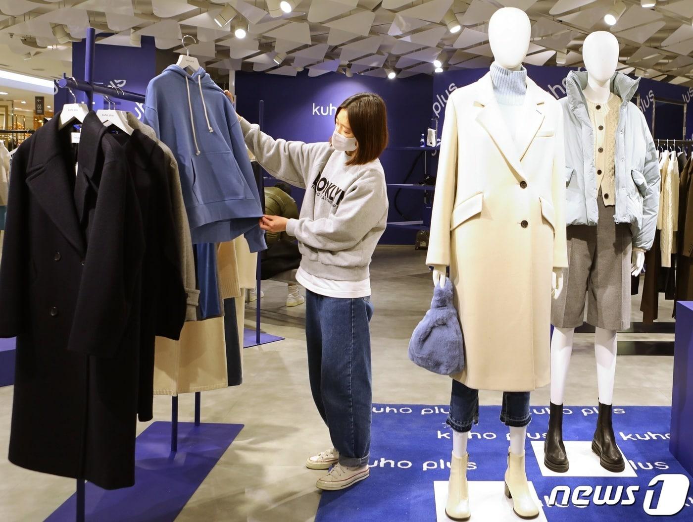 본문 이미지 - 7일 서울 중구 소공동 롯데백화점 본점 '구호플러스(KUHO PLUS)' 팝업 매장에서 모델들이 상품을 살펴보고 있다.(롯데쇼핑 제공) 2021.12.7/뉴스1