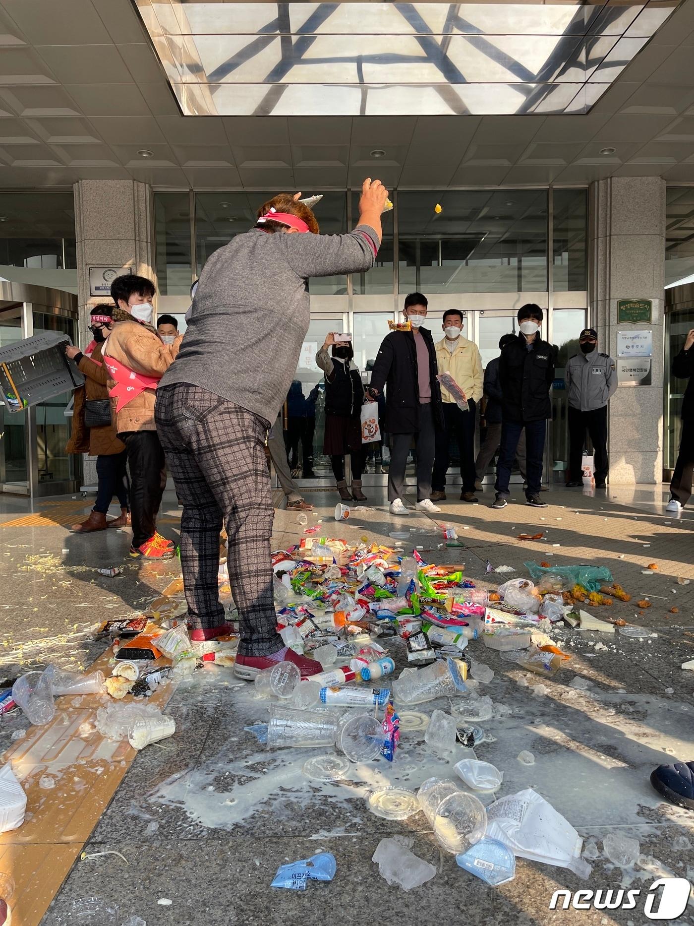 본문 이미지 - 7일 충북 충주라이트월드 상인들이 충주시의 상가 단전·단수에 항의해 시청 현관에 아이스크림을 투척하고 있다.2021.12.7/ⓒ 뉴스1