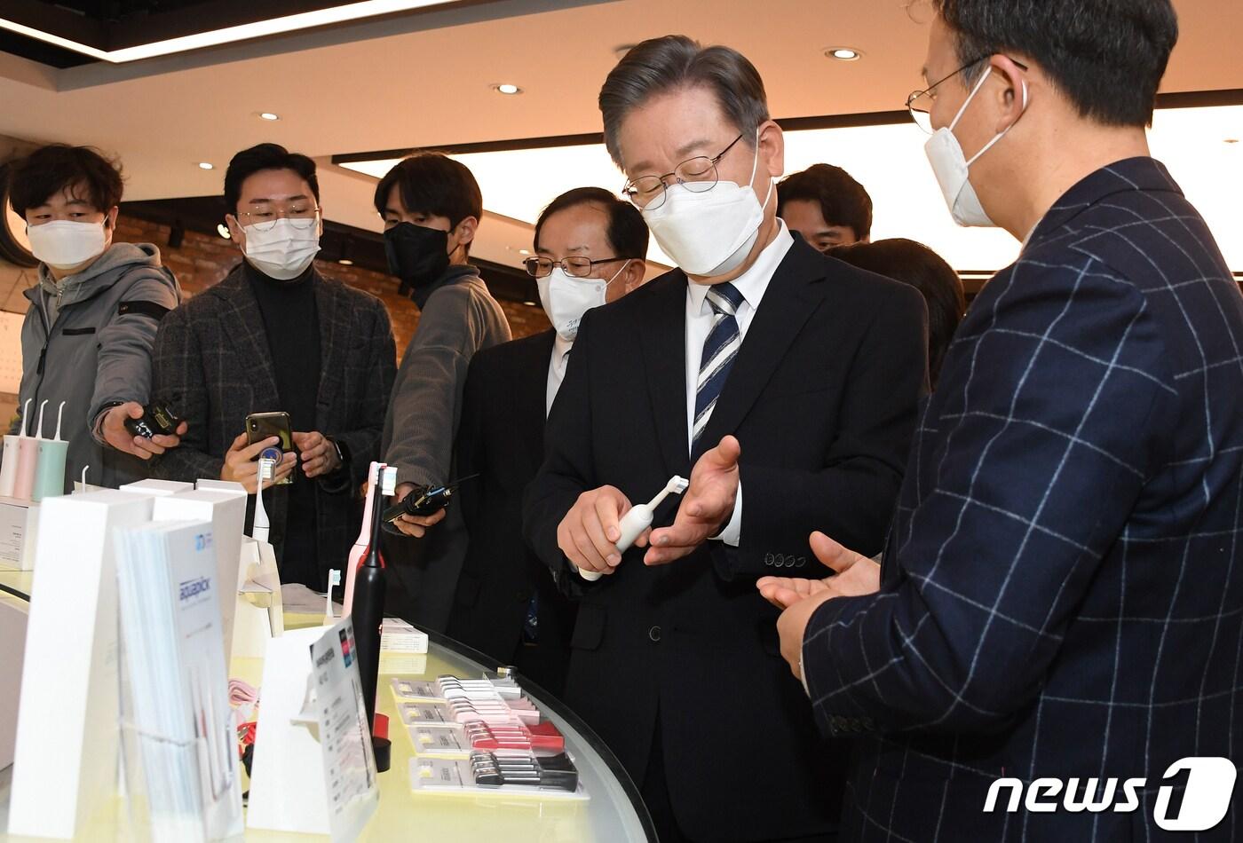 본문 이미지 - 이재명 더불어민주당 대선 후보가 8일 오전 서울 금천구 가산디지털단지 아쿠아픽 대회의실에서 열린 중소·벤처기업 정책 공약 발표에 앞서 중소기업 제품들을 살펴보고 있다. 2021.12.8/뉴스1 ⓒ News1 국회사진취재단