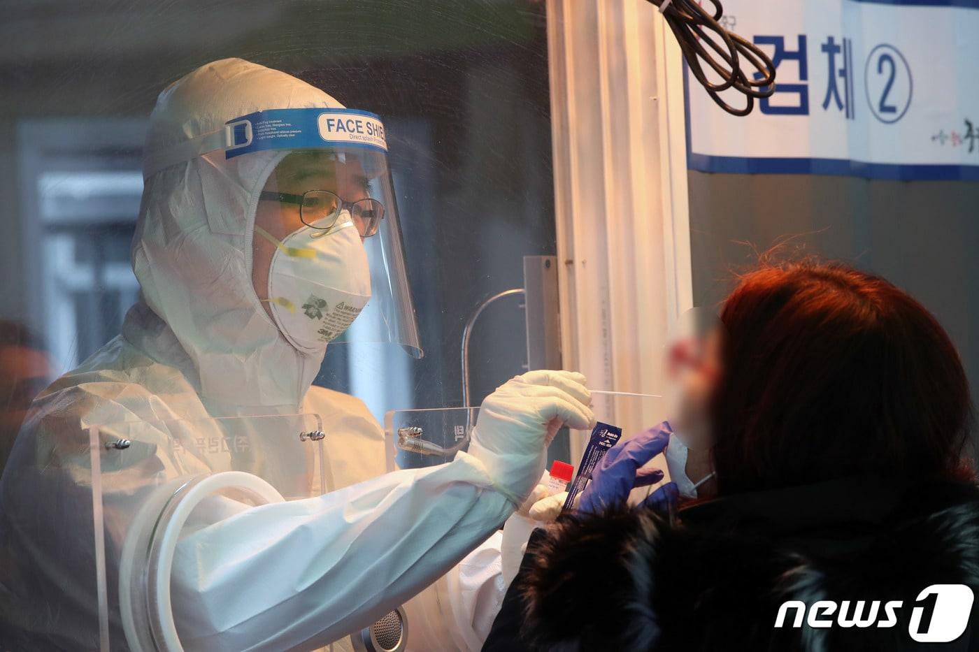 본문 이미지 - 11일 중구 봉래동 서울역 광장에 마련된  코로나19 중구 임시선별검사소에서 의료진이 검사에 나선 시민의 검체를 체취하고 있다. 2021.2.11/뉴스1 ⓒ News1 박정호 기자