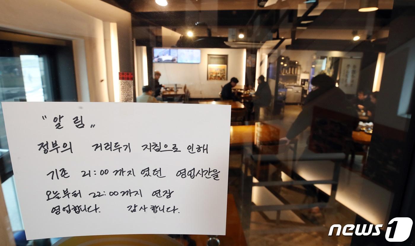 본문 이미지 - 15일 서울 시내 한 식당에 영업 시간이 오후 10시로 연장된다는 문구가 붙어 있다. ⓒ News1 김진환 기자