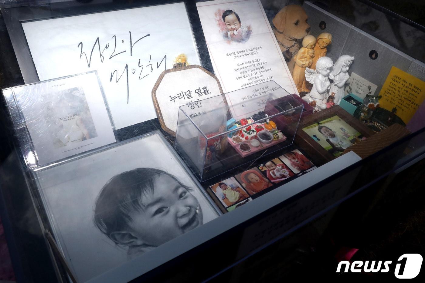 본문 이미지 - 양부모의 학대로 숨진 16개월 영아 '정인이 사건' 2차 공판날인 17일 오후 경기 양평군 하이패밀리 안데르센 공원묘원에 정인(가명)양의 사진이 놓여 있다. 2021.2.17/뉴스1 ⓒ News1 이동해 기자