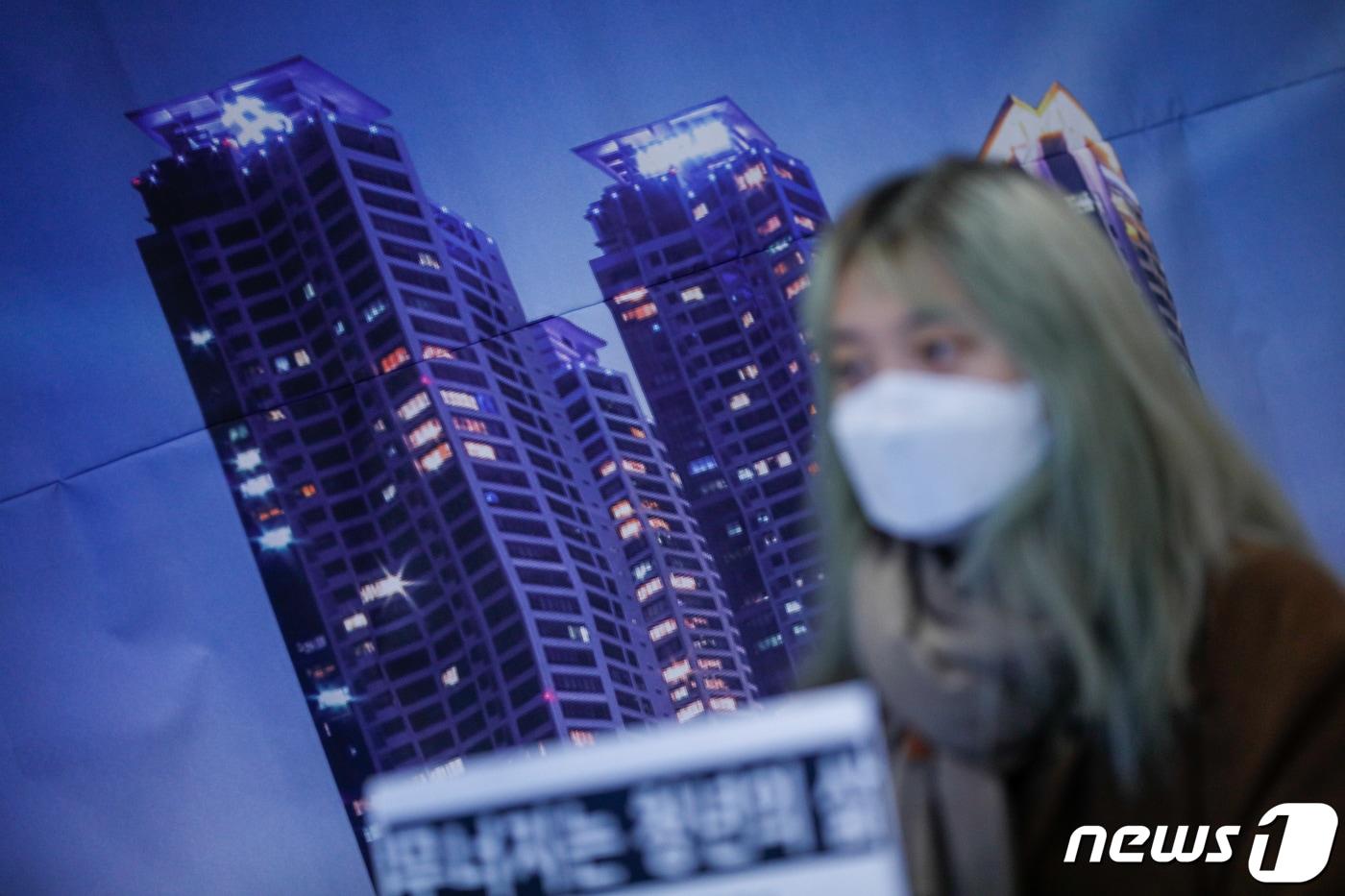 본문 이미지 - 한 활동가가 불평등 해소 촉구 기자회견에서 '무너지는 청년의 삶'이라는 손팻말을 들고 있다. (자료사진) /뉴스1