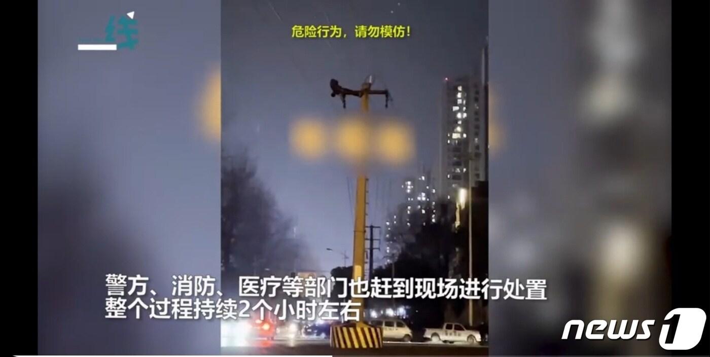 본문 이미지 - 지난 21일 중국 청도 남서부지역 외곽에서 한 남성이 전신주에 올라가 윗몸일으키기를 하고 있다.(웨이보 갈무리)ⓒ 뉴스1