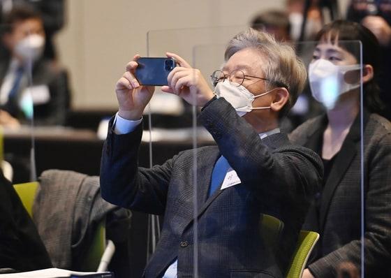 본문 이미지 - 이재명 경기도지사가 ㅈ;ㅣ난 2월 25일 경기도 수원시 영통구 수원컨벤션센터에서 열린 경기도 기본주택 컨퍼런스 개막식에 참석해 행사 장면을 핸드폰으로 촬영을 하고 있다. ⓒ News1 경기사진공동취재단