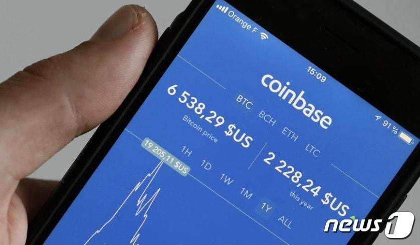 본문 이미지 - 한 투자자가 코인베이스 앱을 이용, 암호화폐 거래를 하고 있다.