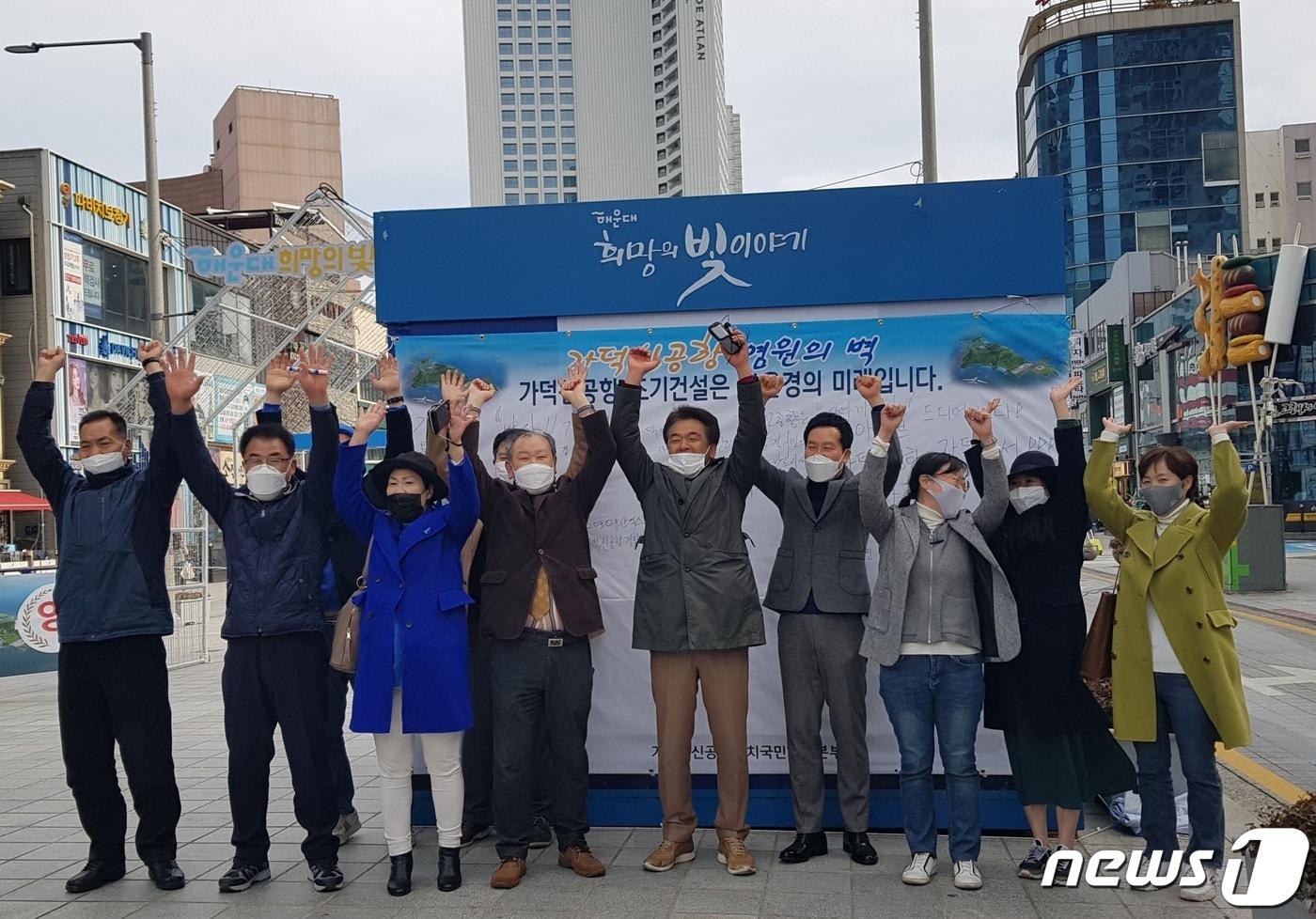 본문 이미지 - 가덕신공항유치 국민행동본부가 26일 오후 해운대구에서 열린 '가덕신공항 염원의 벽 시민참여 캠페인' 행사에서 '가덕신공항 특별법' 통과 소식에 환호하고 있다.(가덕신공항유치 국민행동본부 제공) ⓒ 뉴스1
