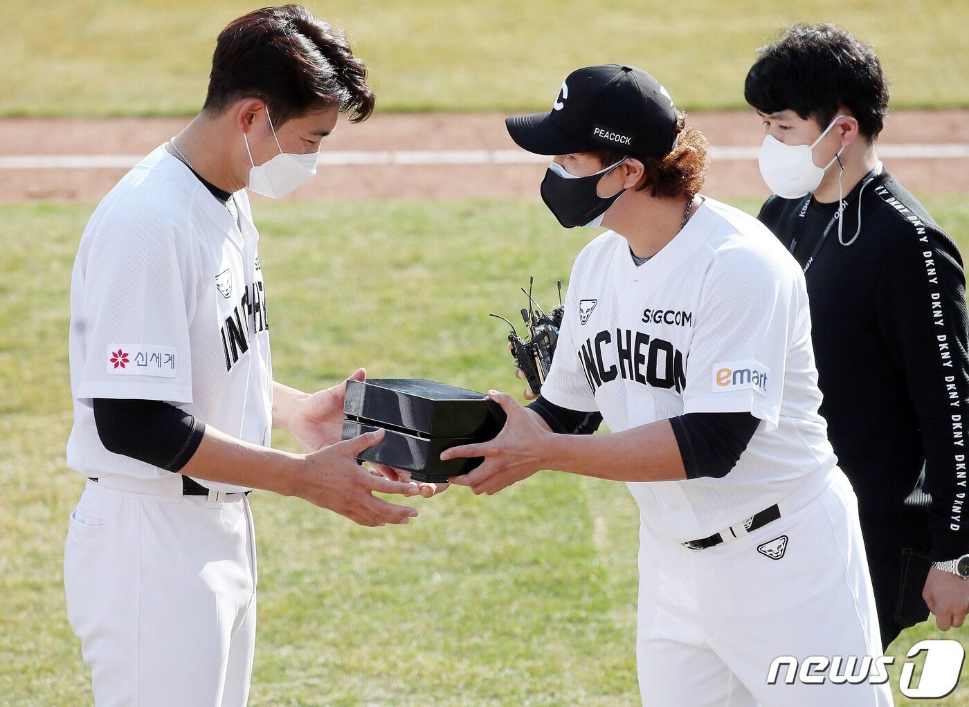 본문 이미지 - 자가격리를 마친 SSG랜더스 추신수가 11일 오후 부산 사직야구장에서 열린 롯데자이언츠와 SSG랜더스의 연습 경기가 끝난 후 팀 상견례에서 등번호 17번을 양보한 이태양(왼쪽)에게 선물을 전달하고 있다. 2021.3.11/뉴스1 ⓒ News1 김진환 기자