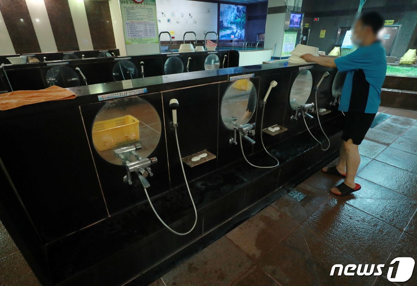 본문 이미지 - 15일 서울의 한 목욕탕에서 마스크를 쓴 세신사가 목욕용품을 정리하고 있다./뉴스1 ⓒ News1 구윤성 기자