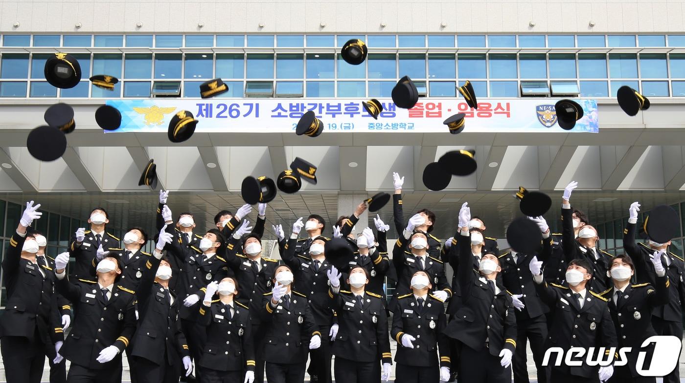 본문 이미지 - 제26기 소방간부후보생 졸업 및 임용식에서 졸업생들이 정모를 던지고 있다. 2021.3.19/뉴스1 ⓒ News1 김기태 기자
