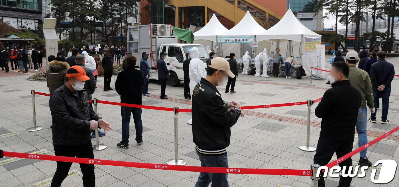 21일 오전 서울 구로역광장에 마련된 임시 선별진료소를 찾은 시민들과 외국인들이 검체 검사를 받기 위해 줄을 서 있다. 2021.3.21/뉴스1 ⓒ News1 이동해 기자