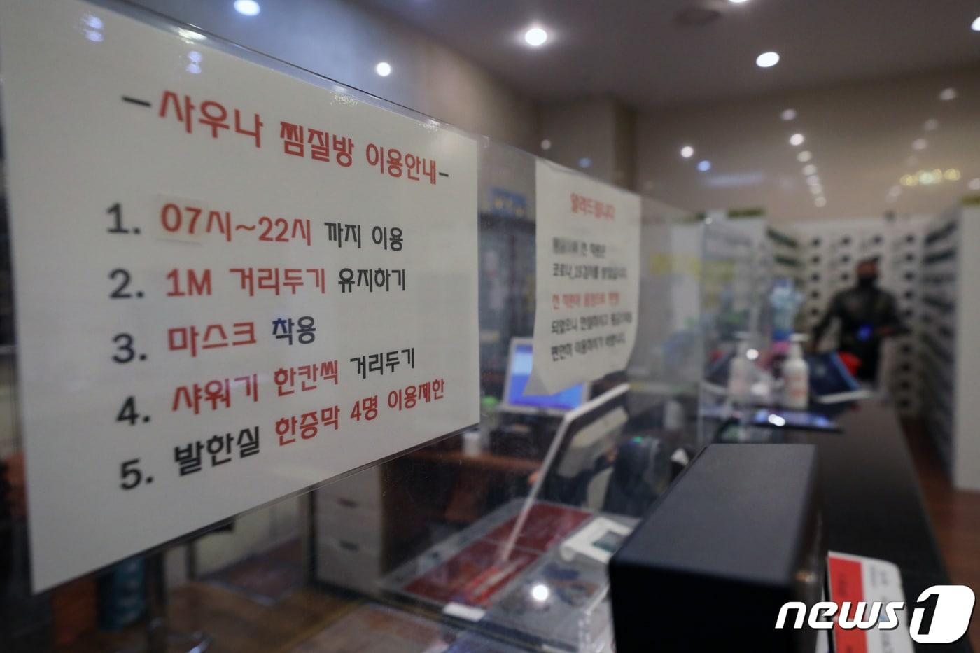 본문 이미지 - 22일 서울 시내의 한 목욕탕 카운터에 코로나19 예방 관련 안내문이 붙어있다. 2021.3.22/뉴스1 ⓒ News1 이승배 기자