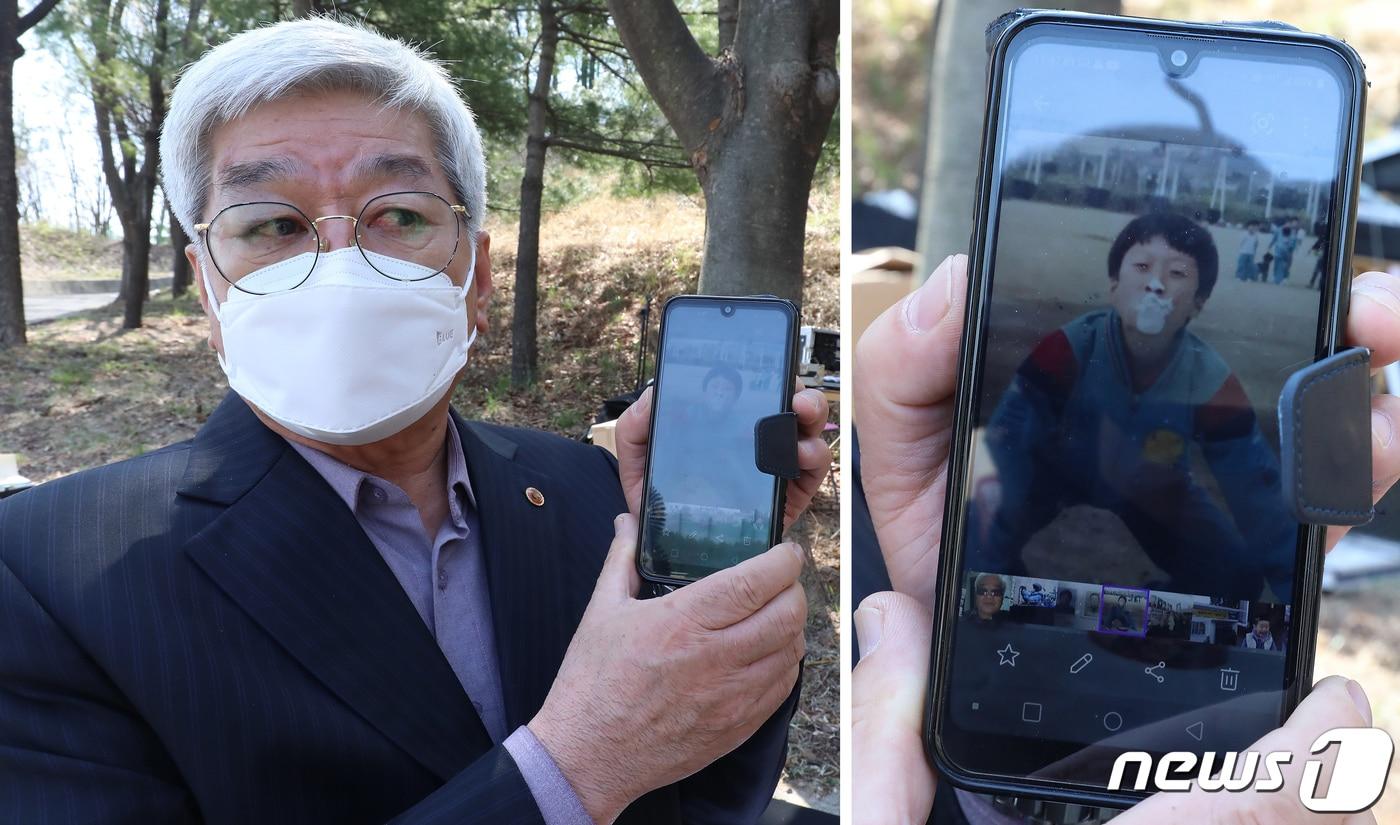 본문 이미지 - 2021년 3월 26일 개구리소년 실종사건 30주년을 맞아 대구 달서구 와룡산 선원공원에서 열린 '개구리소년 추모 및 어린이 안전 기원비' 제막식에서 우철원(당시 13세)군의 아버지 우종우씨가 30년을 간직한 아들의 사진을 보여주고 있다. 2021.3.26/뉴스1 ⓒ News1 공정식 기자