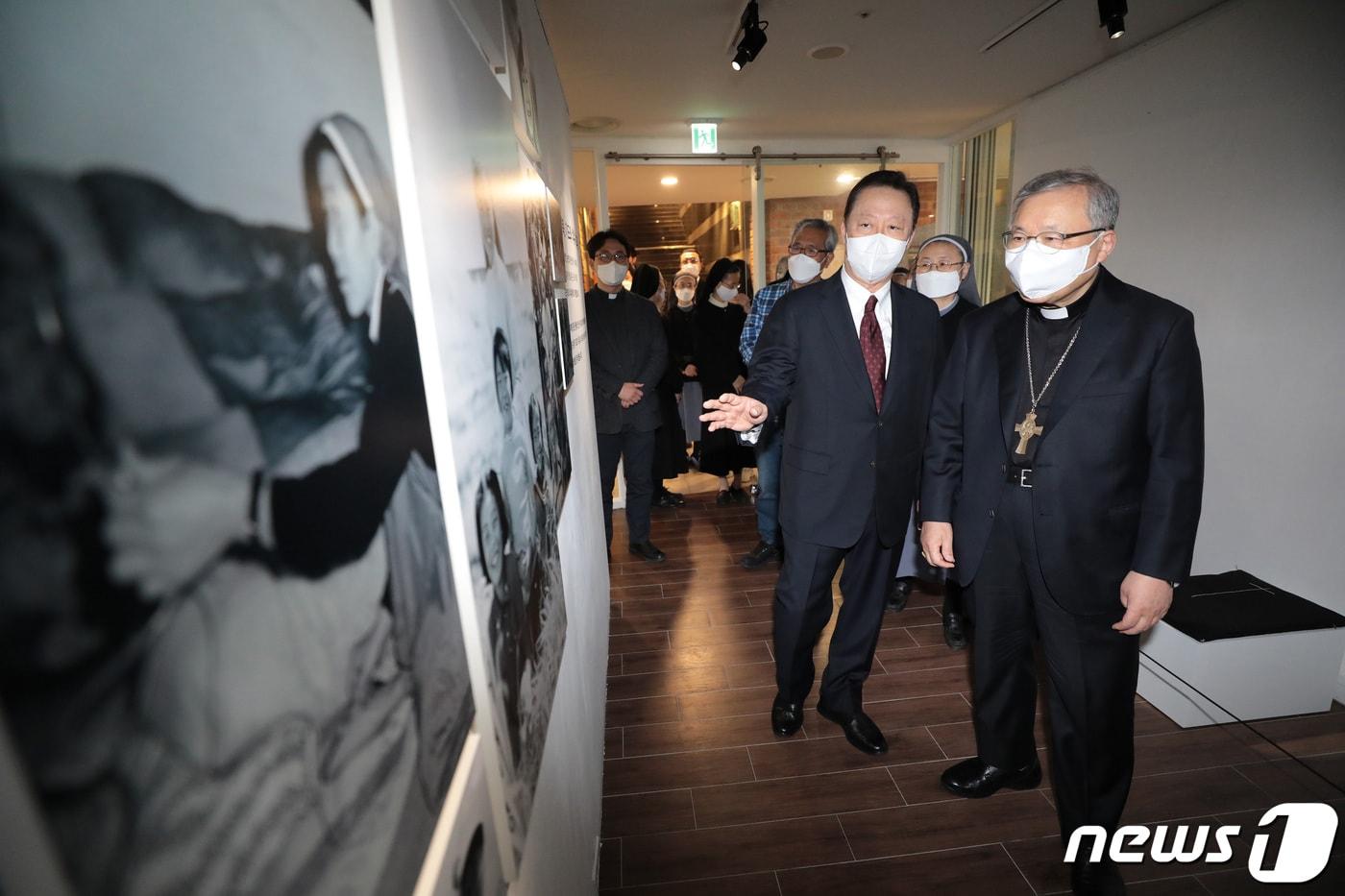 본문 이미지 - 염수정 추기경과 박용만 두산인프라코어 회장이 29일 서울 중구 명동 디아트플랜드 요갤러리에서 열린 '수녀복, 기도와 치유가 되다' 전시장을 둘러보고 있다. 2021.3.29/뉴스1 ⓒ News1 이성철 기자
