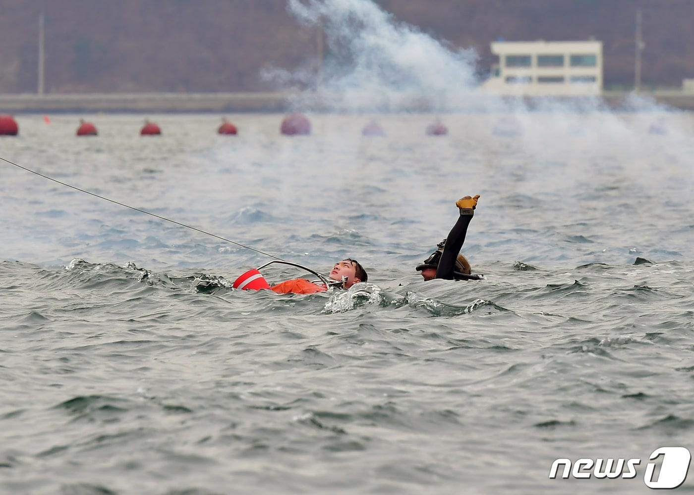 본문 이미지 - 지난 3월4일 경남 진해항에서 실시된 협동 항공구조 훈련에서 해군특수전전단 해난구조대원(SSU)이 해상익수자를 호이스트(Hoist) 방식으로 구조하고 있다. (해군작전사령부 제공) 2021.3.4/뉴스1