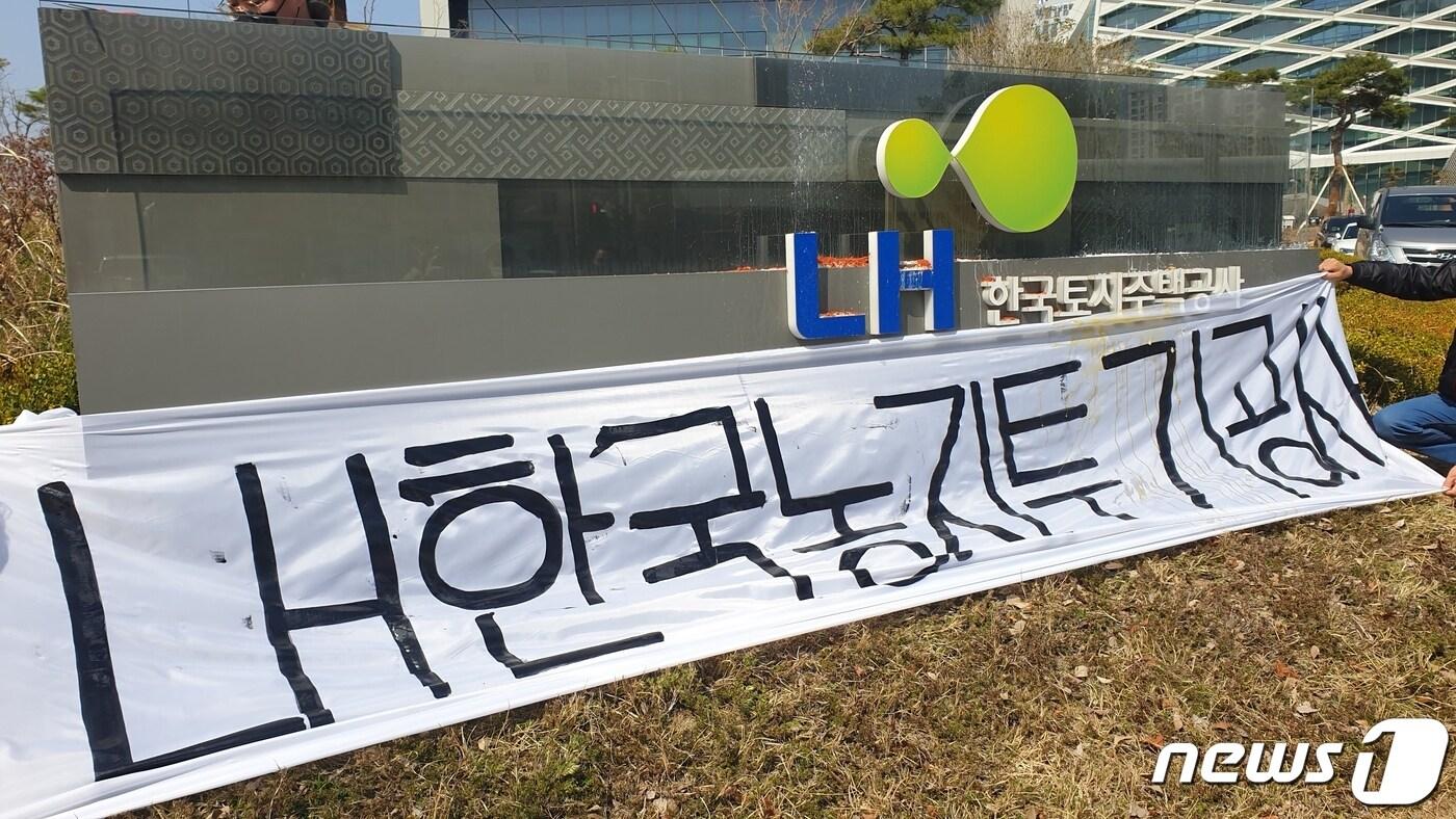 본문 이미지 - 경남 농업인들이 8일 LH 진주 본사를 찾아가 표지석에 'LH한국투기공사'라고 쓰여진 가림막을 걸었다. ⓒ 뉴스1