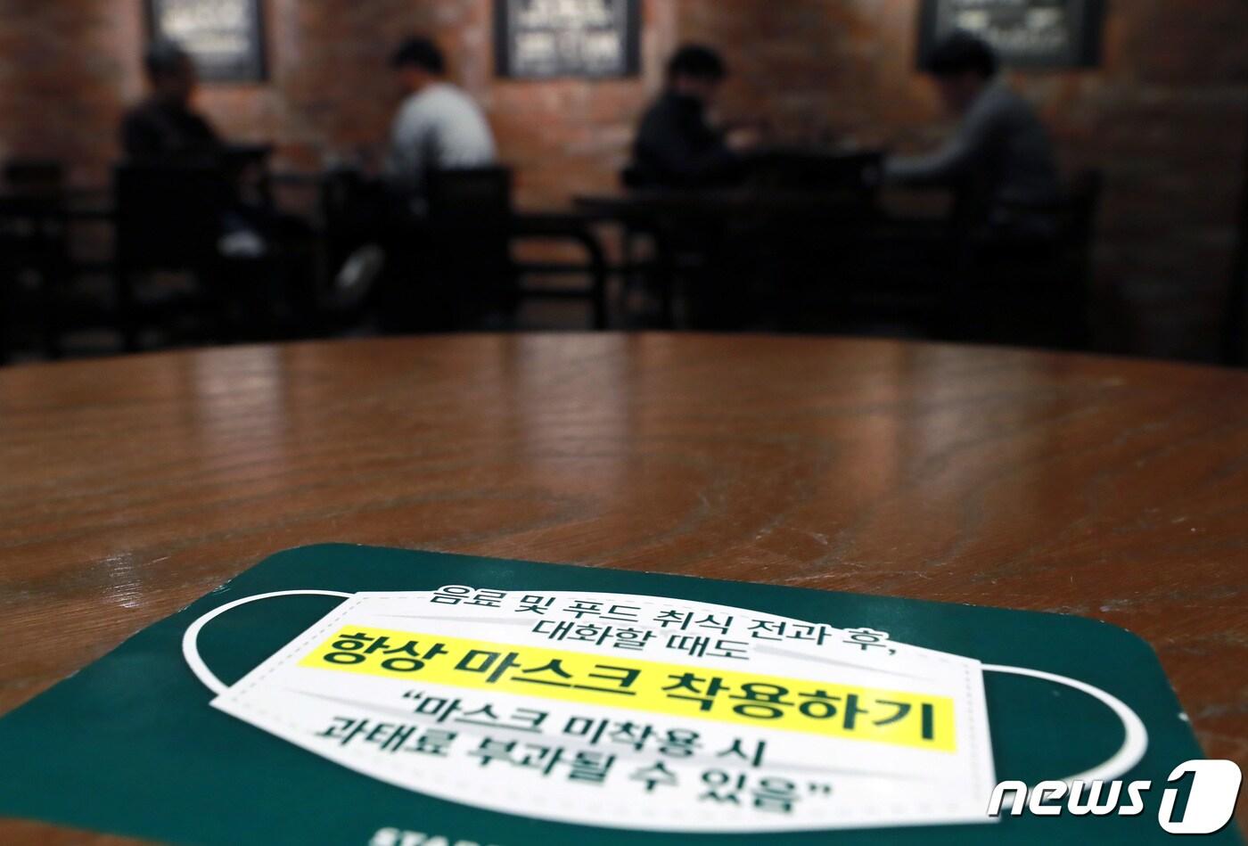 본문 이미지 - '마스크 착용 의무화 조치' 시행 첫날인 12일 오후 서울 시내의 한 커피전문점에 마스크 착용 안내 문구가 붙어 있다. 이날부터 사회적 거리두기 단계에 상관없이 모든 실내에서 마스크를 착용해야 한다. 미착용자에 대해서는 과태료 10만원, 운영 및 관리소홀 책임이 있는 업주 등 관계자에게는 150만원의 과태료가 부과된다. 2021.4.12/뉴스1 ⓒ News1 구윤성 기자