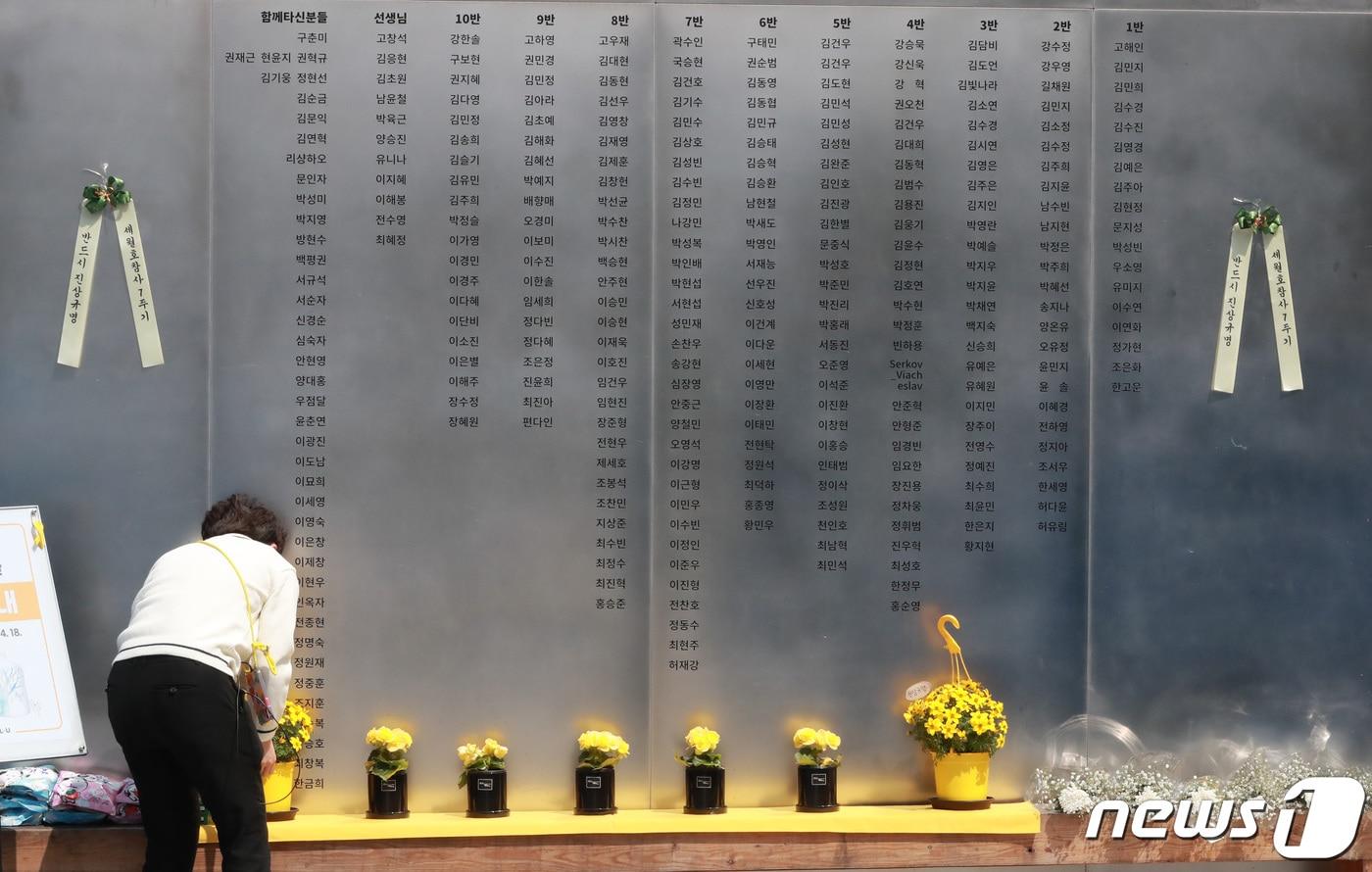 세월호 참사 7주기를 하루 앞둔 지난 4월15일 서울 광화문광장 세월호 기억공간에서 현장 관계자가 희생자들의 명단 앞에 화분을 올리고 있다. 2021.4.15/뉴스1 ⓒ News1 구윤성 기자