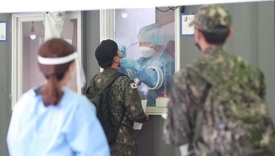 본문 이미지 - 지난 23일 오후 서울 중구 서울역 광장 임시선별검사소에서 의료진이 군인의 검체를 채취하고 있다. ⓒ News1 