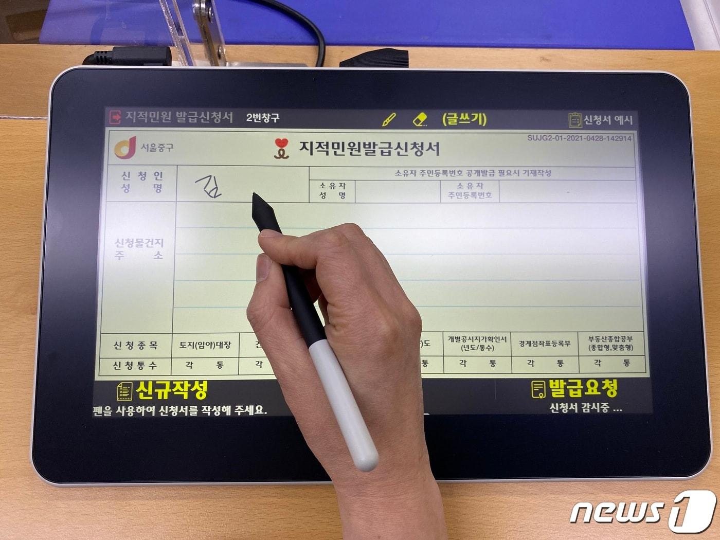 본문 이미지 - 서울 중구의 민원인이 태블릿PC로 부동산 민원신청서를 작성하는 모습.(중구 제공)ⓒ 뉴스1