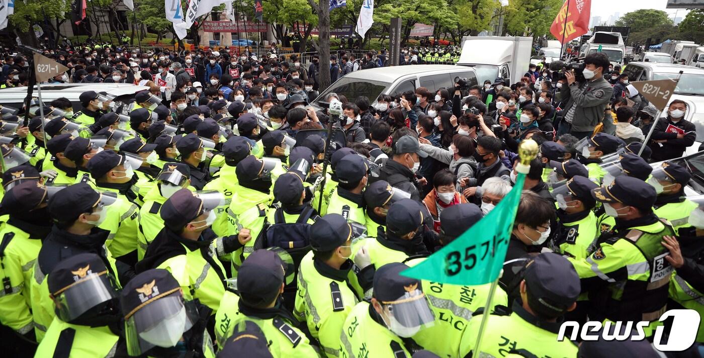 본문 이미지 - 근로자의 날인 1일 서울 영등포구 여의도 LG트윈타워 앞에서 열린 '131주년 세계노동절대회'에서 행진 시작과 함께 민주노총 공공운수노조 조합원들과 경찰들이 충돌을 빚고 있다. 이날 경찰은 신종 코로나바이러스 감염증(코로나19) 확산 방지를 위해 거리두기를 유지하며 9명씩 행진을 허용했다. 2021.5.1 /뉴스1 ⓒ News1 황기선 기자