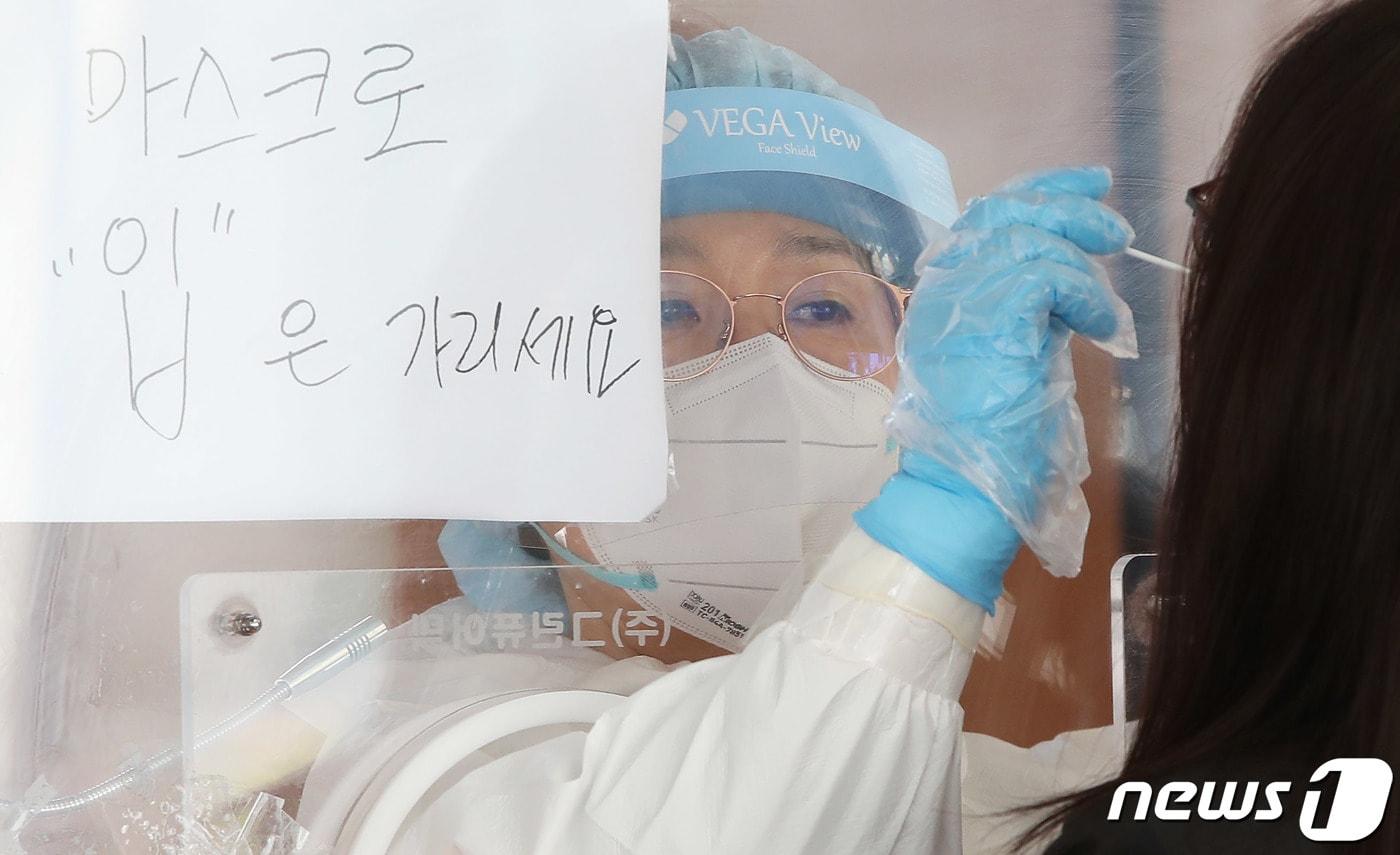 본문 이미지 - 서울 중구 봉래동 서울역 광장에 마련된 코로나19 중구 임시선별검사소를 찾은 시민이 검체 검사를 받고 있다.ⓒ News1 박정호 기자