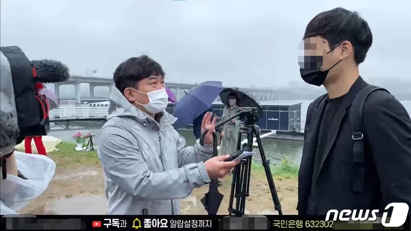 16일 '고(故)  손정민군을 위한 평화집회'에서 후원받는 유튜버 A씨(오른쪽)를 인터뷰하는 SBS '그것이 알고싶다' PD(왼쪽)의 모습. (유튜브 '종이의 TV' 영상 갈무리) ⓒ 뉴스1