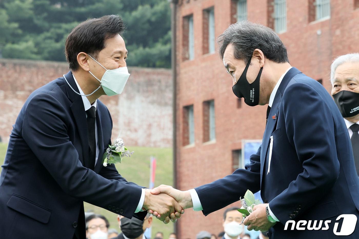 본문 이미지 - 2021년 5월 18일 오세훈 서울시장과 이낙연 전 더불어민주당 대표가 서울 서대문형무소 역사관에서 열린 5·18민중항쟁 제40+1주년 서울기념식에 참석해 인사를 나누고 있다. 2021.5.18 ⓒ 뉴스1 DB