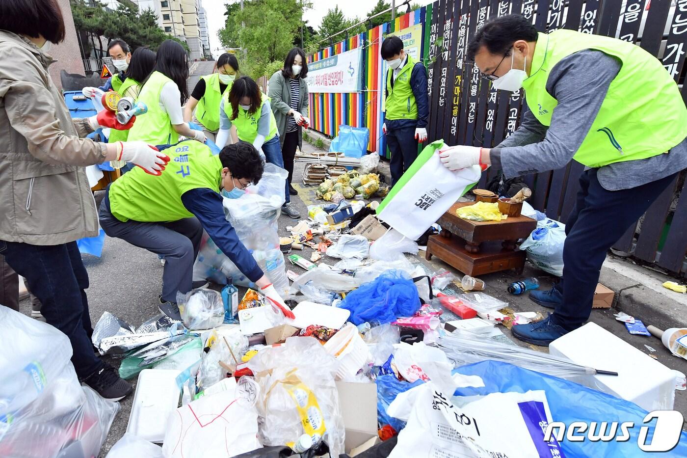 수원시 공직자들이 매탄1동의 한 주택가에서 쓰레기를 올바르게 분리하는 작업을 하고 있다. ⓒ 뉴스1