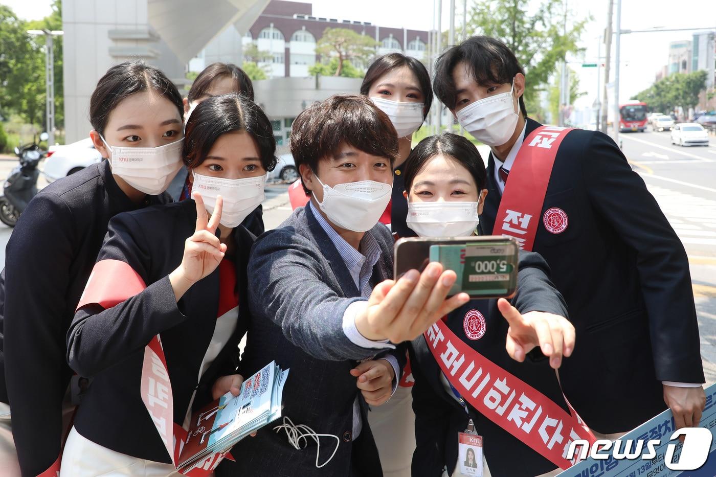 본문 이미지 - 국민의힘 당 대표 출마를 선언한 이준석 전 최고위원이 24일 오후 대구 북구 경북대학교 북문 앞에서 대학생들과 인사 나누며 기념사진을 찍고 있다. 2021.5.24/뉴스1 ⓒ News1 공정식 기자