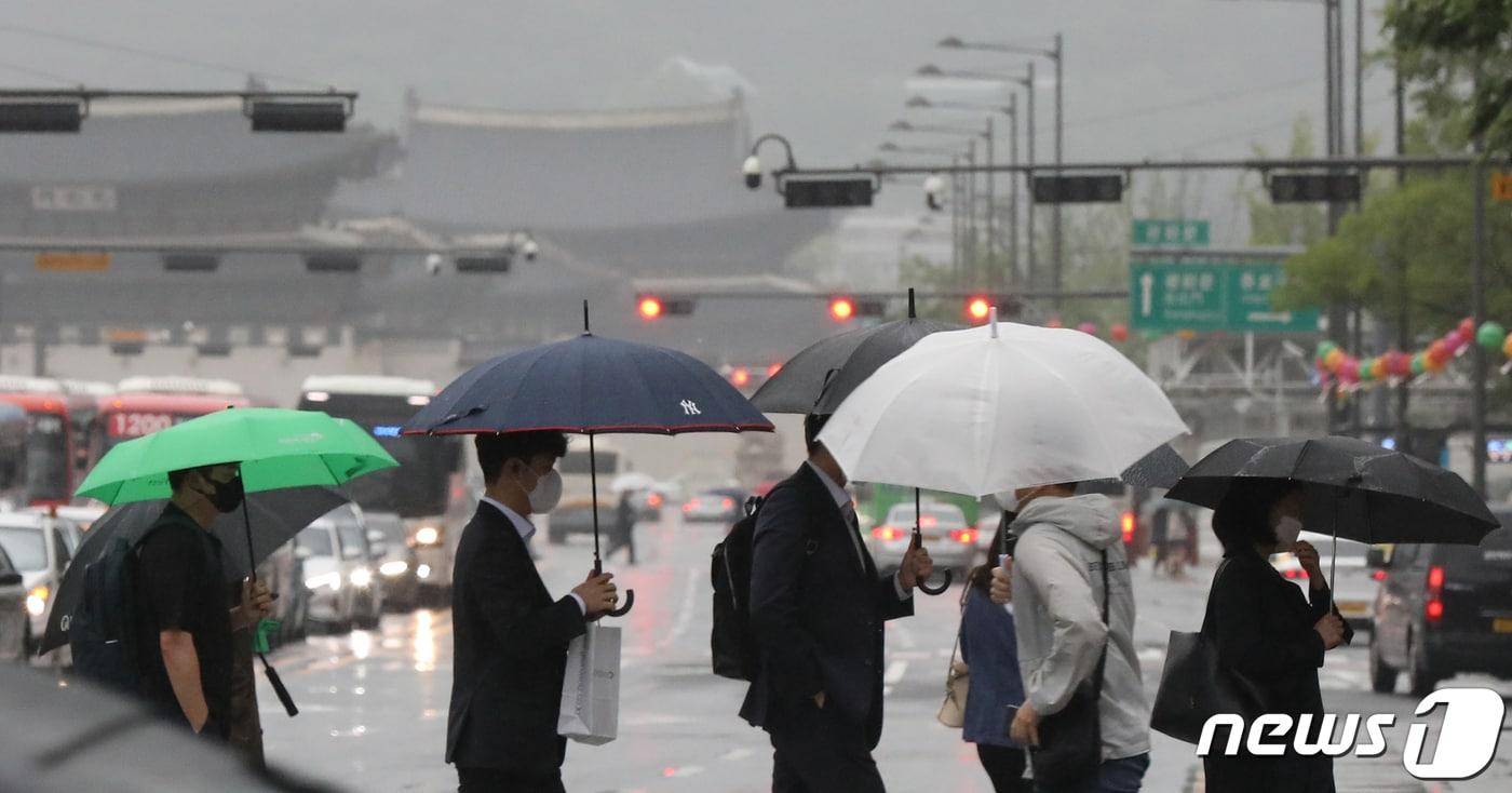 지난 2021년 5월 전국 대부분 지역에 '황사비'가 내린 가운데 서울 종로구 광화문 네거리에서 우산을 쓴 시민들이 출근길 발걸음을 재촉하고 있다. ⓒ News1 민경석 기자