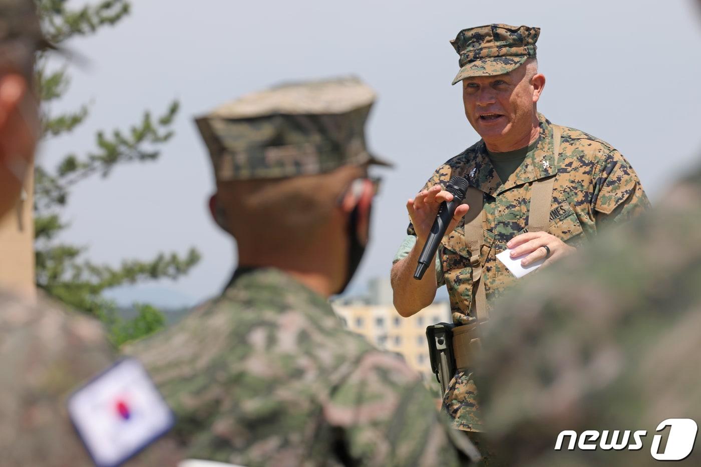 본문 이미지 - 28일 경북 포항시 남구 오천읍에 주둔하는 미해병대 캠프무적에서 열린 부대장 이취임식에서 신임 부대장인 데니스 L.헤이거 대령이 행사에 참석한 대한민국 해병대 간부들에게 "함께 갑시다＂란 말로 인사를 건네고 있다. 2021.5.28 /뉴스1 ⓒ News1 최창호 기자