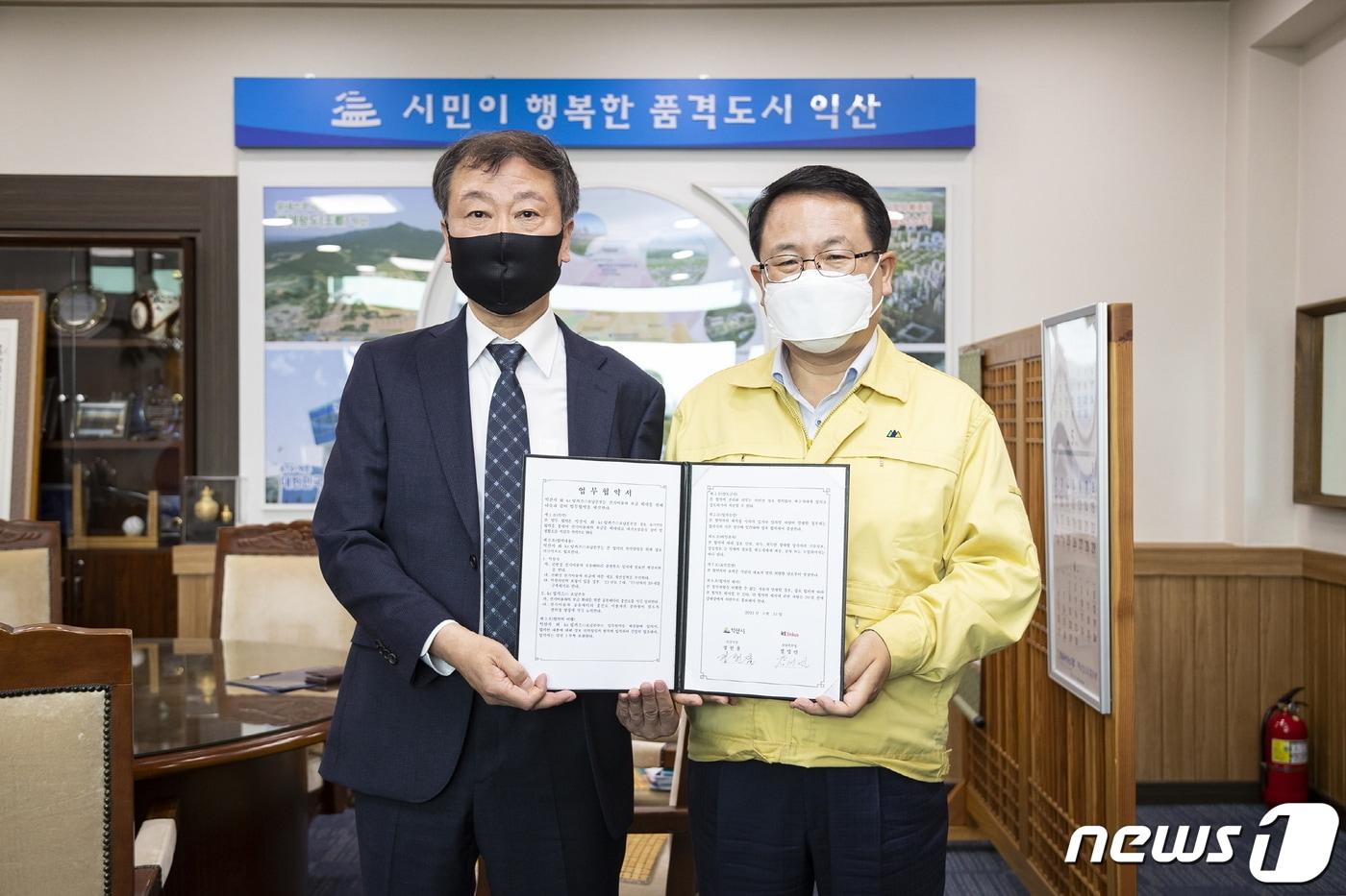 본문 이미지 - 정헌율 익산시장(오른쪽)과 장영민 KT링커스 호남본부장이 ‘전기이륜차 배터리 교환형 충전인프라 구축’을 위한 업무협약을 체결하고 있다(익산시 제공)2021.5.31/뉴스1