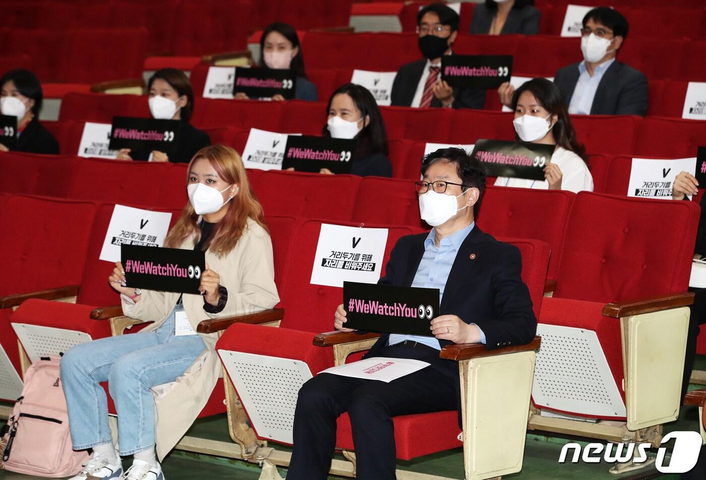 본문 이미지 - 박범계 법무부 장관이 취임 100일을 맞은 7일 오후 경기도 과천시 정부과천청사 대강당에서 열린 디지털성범죄 고발 리얼 다큐멘터리 영화 '#위왓치유' 시사회에서 법무부 직원들과 함께 디지털 성범죄 경각심을 알리는 피켓을 들고 있다. 2021.5.7/뉴스1 ⓒ News1 오대일 기자