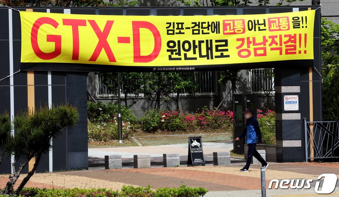 본문 이미지 - 김포시민들이 정부의 김포~부천 GTX-D노선 발표에 반발하고 있는 가운데, 8일 김포시 구래동의 한 아파트에 현수막이 걸려 있다. 2021.5.8/뉴스1 ⓒ News1 정진욱 기자