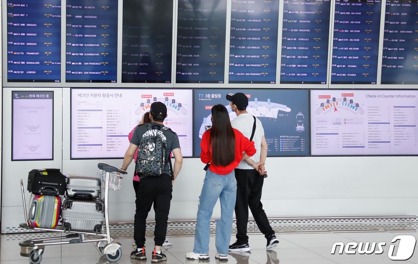 본문 이미지 - 여행객들이 11일 오후 인천국제공항 제1터미널에서 출국하기 전 항공편 정보를 보고 있다. 정부는 코로나19 백신 접종 완료자에 한해 이르면 7월부터 싱가포르와 괌, 사이판 등 단체 해외여행을 허용하는 여행안전권역(트래블 버블)을 추진한다고 밝혔다. 2021.6.11/뉴스1 ⓒ News1 권현진 기자