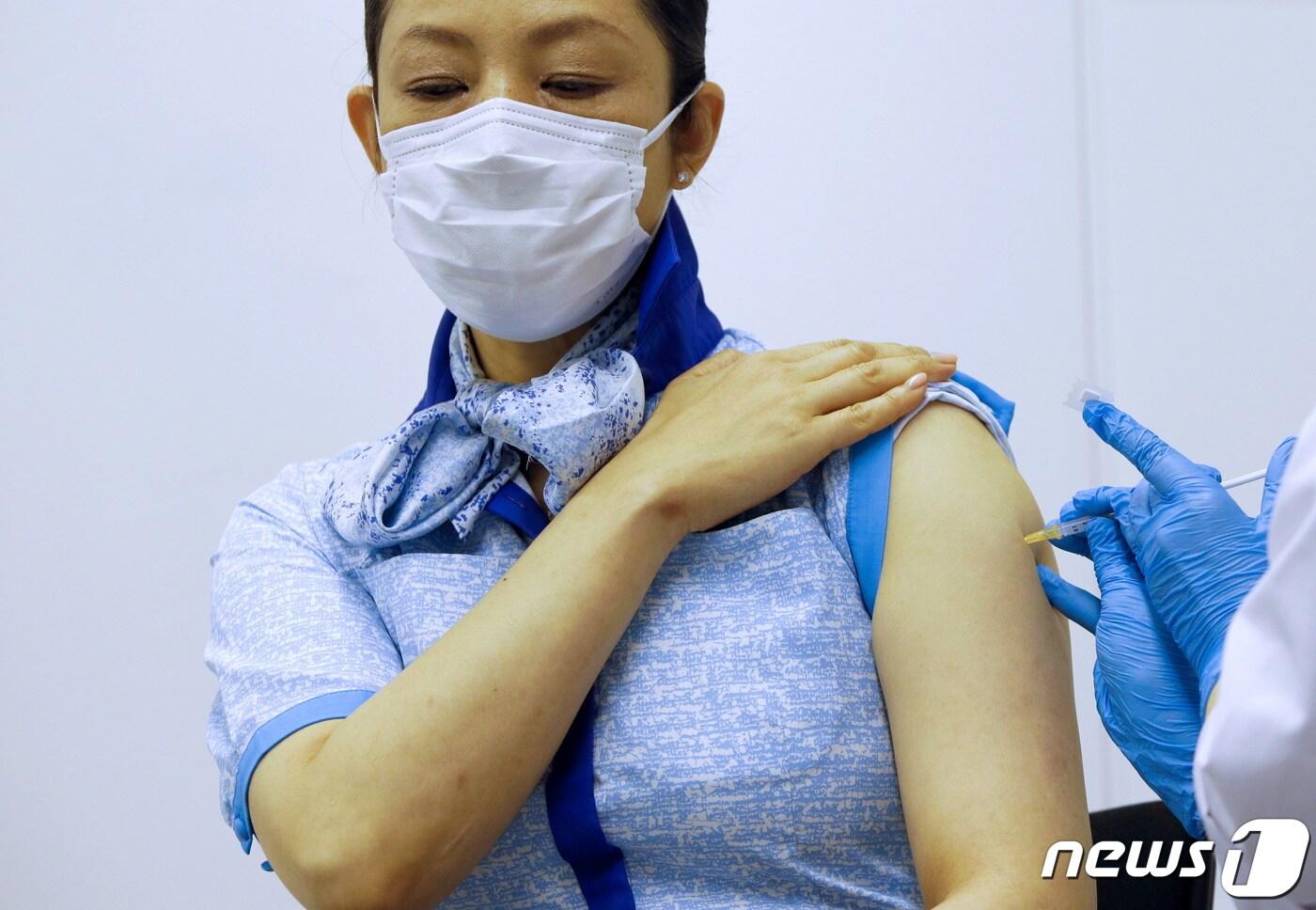 본문 이미지 - ANA홀딩스가 일본 기업 최초로 국제선 승무원을 대상으로 13일 코로나19 백신을 접종하고 있다. ⓒ 로이터=뉴스1 ⓒ News1 원태성 기자