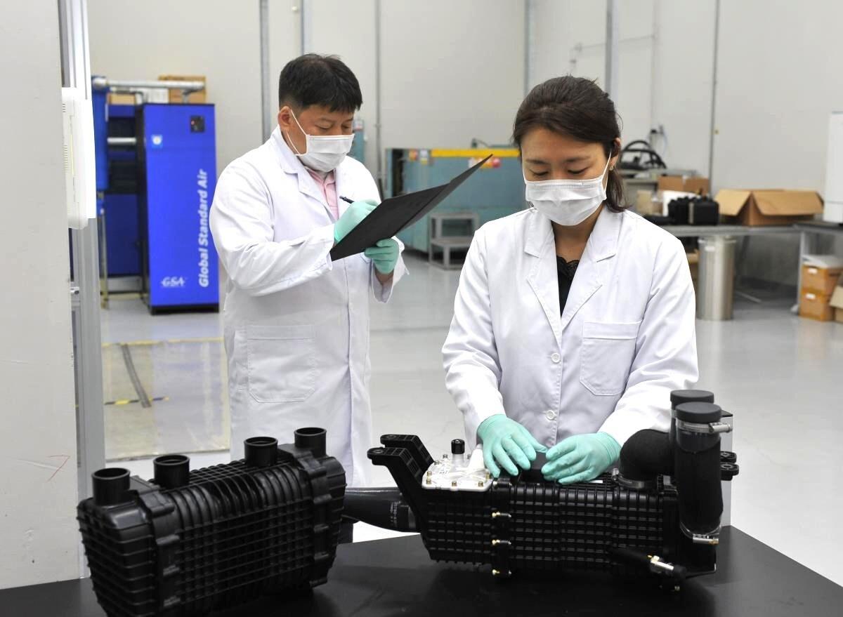 본문 이미지 - 코오롱인더스트리 연구원들이 현대자동차의 차세대 수소연료전지 시스템에 공급되는 수분제어장치를 점검하고 있다(코오롱인더스트리 제공). ⓒ 뉴스1