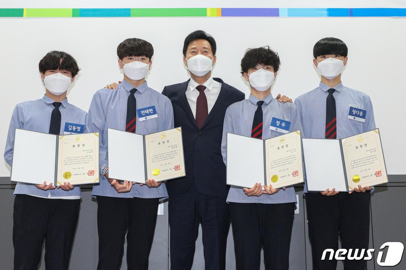 본문 이미지 - 오세훈 서울시장이 18일 오전 서울 중구 환일고등학교에서 열린 '재난현장 의로운 시민1호 표창 수여식'에서 학생들에게 표창장을 수여하고 기념촬영을 하고 있다. 환일고 학생들은 지난 5월 마포대교에서 난간에 매달려 투신을 시도하던 남성을 발견, 구조했다. 사진 왼쪽부터 김동영, 전태현, 오 시장, 정두, 정다운. 2021.6.18/뉴스1 ⓒ News1 성동훈 기자