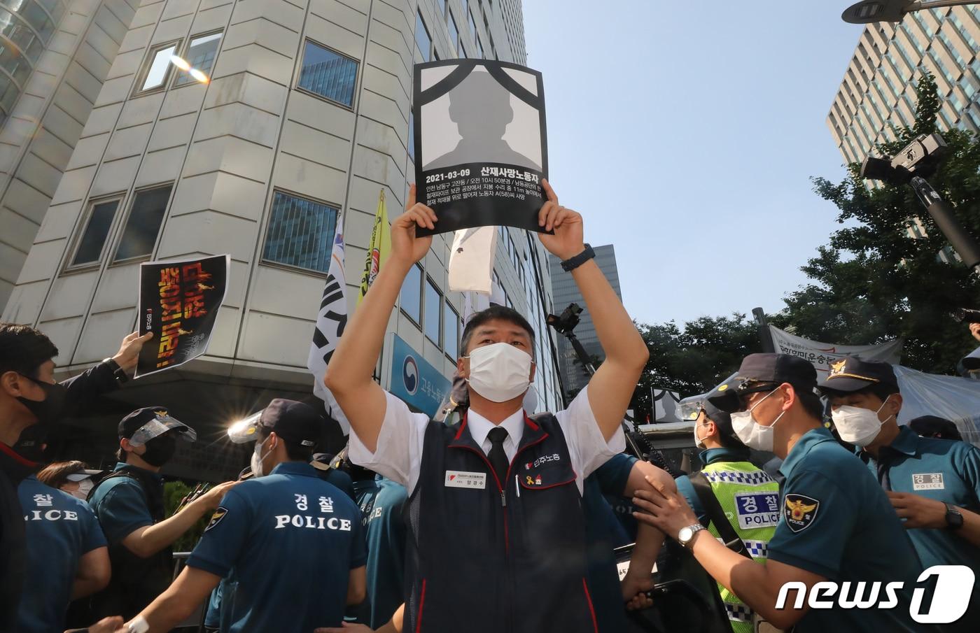 본문 이미지 - 19일 서울 중구 서울고용노동청 앞에서 민주노총 주최로 열린 '더 이상 죽이지 마라!' 중대재해 노동자 합동추모제 집회에서 양경수 민주노총 위원장이 산재로 숨진 노동자 영정을 들고 시위를 하고 있다. 2021.6.19/뉴스1 ⓒ News1 ,송원영 기자
