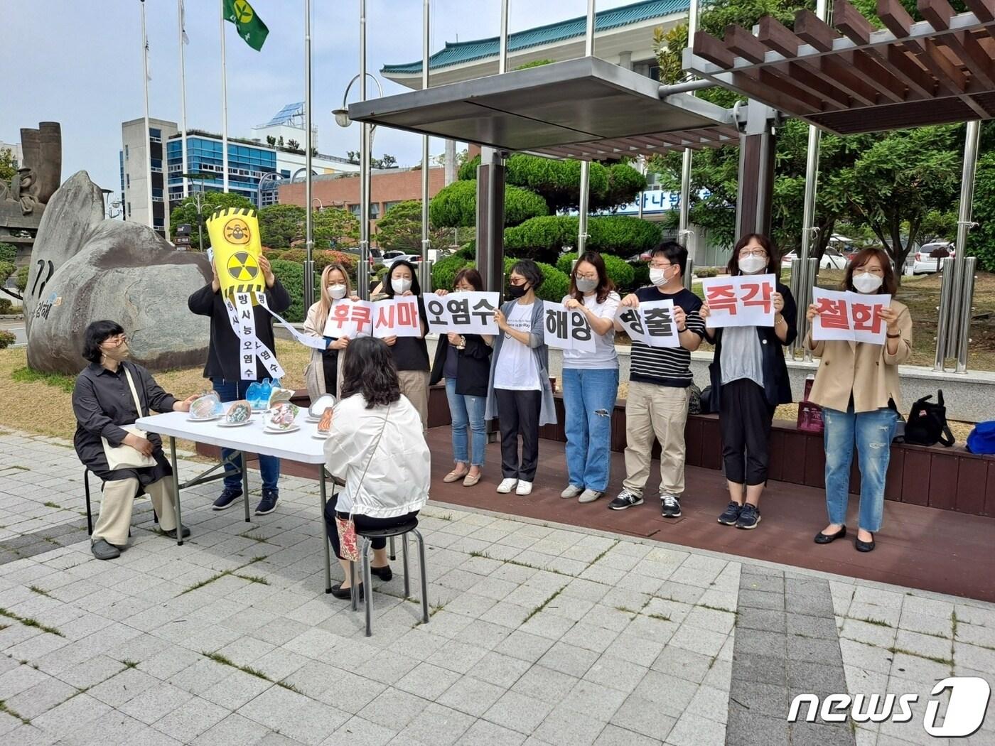 본문 이미지 - 김해기후위기비상행동이 2일 오전 10시 기자회견을 갖고 식탁 위에 방사능 오염수를 붓는 퍼포먼스를 하고 있다. ⓒ 뉴스1 김명규기자.