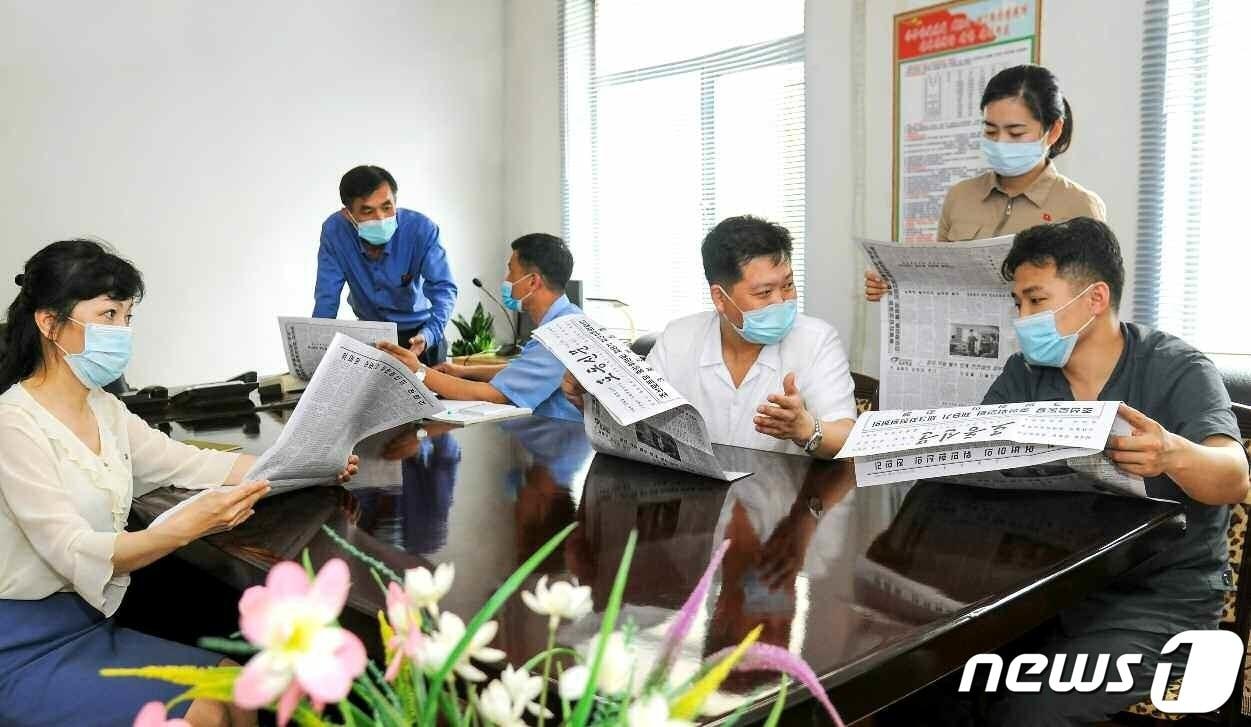 본문 이미지 - (평양 노동신문=뉴스1) =사진은 노동신문에 실린 전원회의 보도를 보고 있는 금속공업성 주민들. [국내에서만 사용가능. 재배포 금지. DB 금지. For Use Only in the Republic of Korea. Redistribution Prohibited] rodongphoto@news1.kr