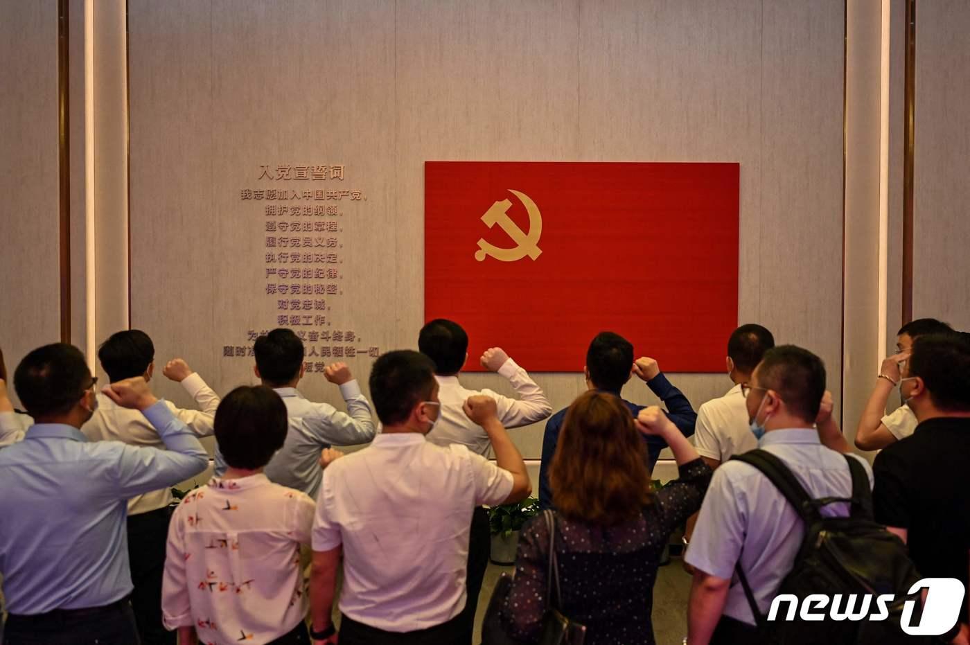 중국공산당 창립 100주년을 맞아 중국인들이 공산당 붉은 깃발 앞에서 주먹을 쥐고 있다. 2021.06.22 ⓒ AFP=뉴스1