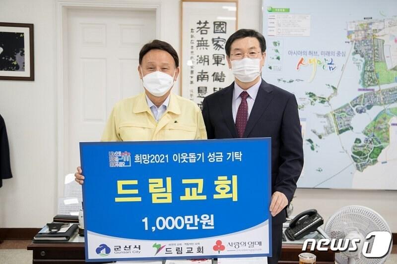 본문 이미지 - 임만호 군산드림교회 담임목사(사진 오른쪽)가 강임준 군산시장에게 이웃돕기 성금을 기탁하고 있다.ⓒ 뉴스1