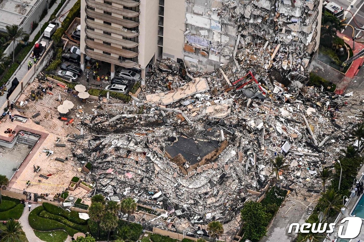 24일(현지시간) 플로리다주 마이애미의 서프사이드에 있는 12층 짜리 챔플레인 타워 콘도 건물이 폭격 맞은 듯 무너져 1명이 사망하고 99명이 실종된 현장의 모습이 보이고 있다. ⓒ AFP=뉴스1 ⓒ News1 우동명 기자