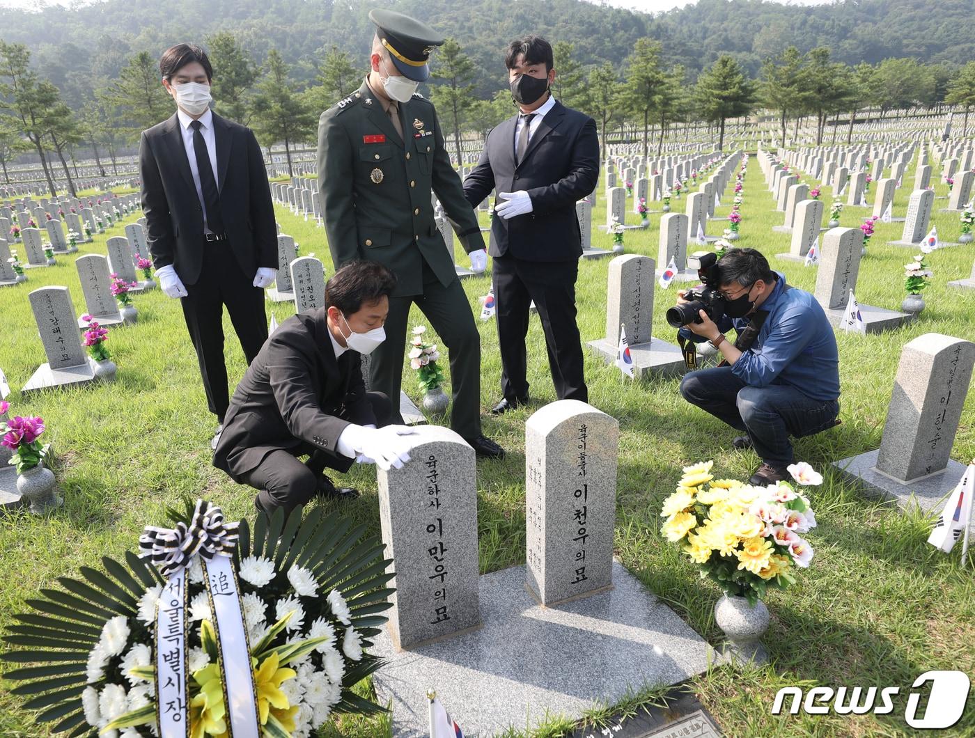 본문 이미지 - 오세훈 서울시장이 6.25전쟁 제71주년인 25일 서울 동작구 국립서울현충원에서 이만우·이천우 호국 형제의 묘를 참배하고 있다. 2021.6.25/뉴스1 ⓒ News1 신웅수 기자