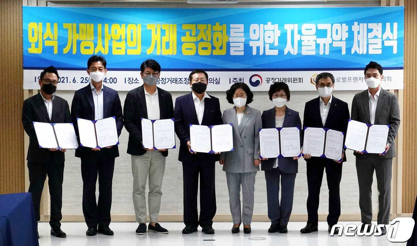 본문 이미지 - 롯데GRS와 투썸플레이스, 제너시스비비큐, 맘스터치앤컴퍼니, 놀부, 이랜드이츠가 25일 오후 서울 중구 공정거래조정원에서 '외식 가맹사업의 거래 공정화를 위한 자율규약 체결식'을 가지고 기념사진을 찍고 있다. 왼쪽부터 김동전 맘스터치앤컴퍼니 대표, 안세진 놀부 대표, 차우철 롯데GRS 대표, 이승창 글로벌프랜차이즈 협의회 협회장, 조성욱 공정거래위원장, 윤경주 제너시스비비큐 대표, 이영상 투썸플레이스 대표, 김영 이랜드이츠 운영본부장. ⓒ 뉴스1 황덕현 기자