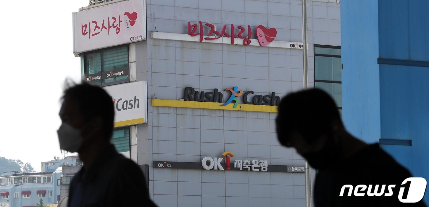 본문 이미지 - 27일 서울의 한 대부업체와 저축은행 건물 앞으로 시민들이 지나가고 있다.  2021.6.27 ⓒ 뉴스1 박지혜 기자